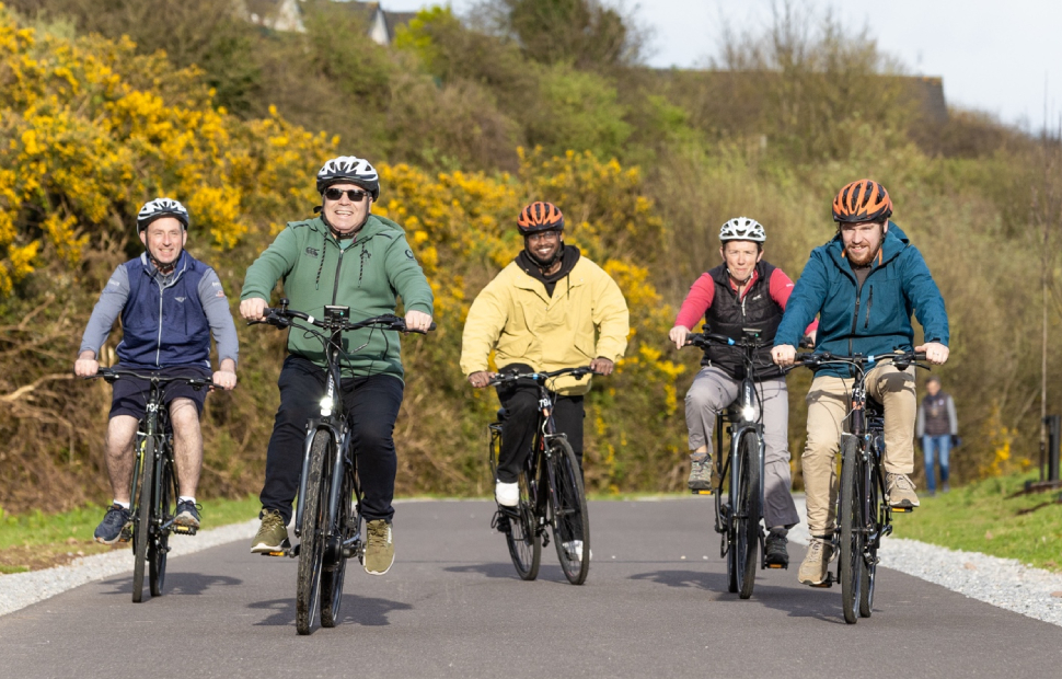 group of men bikers cycling and smiling to the camera